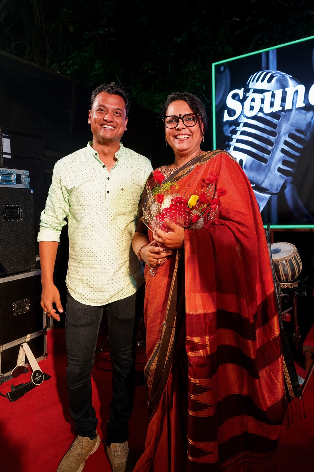 A performer being presented with a bouquet on stage