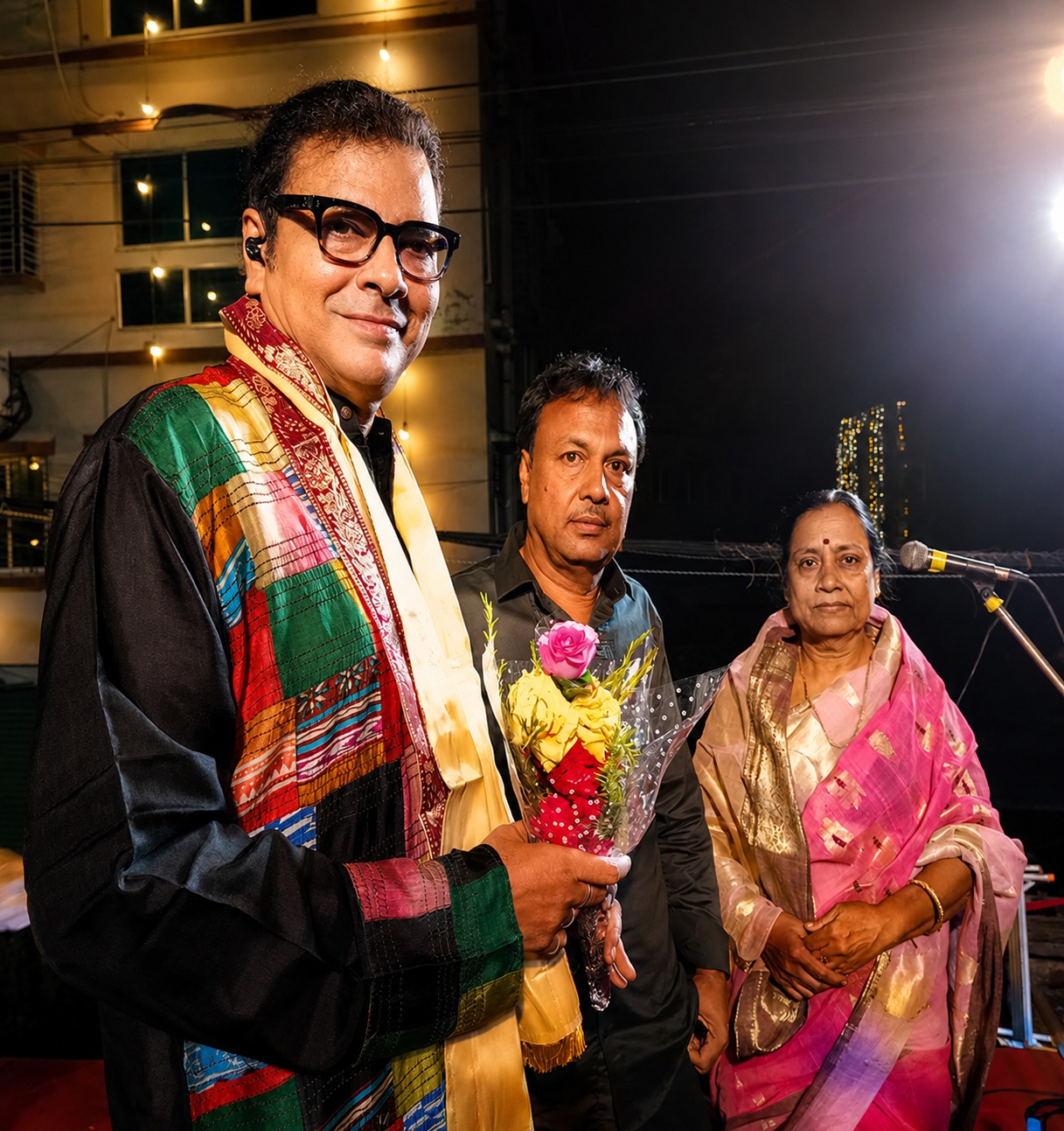 A guest artist honoured on stage alongside two organisers